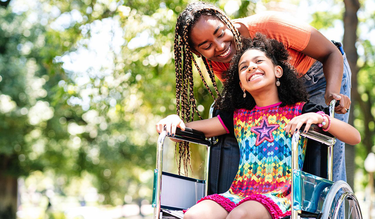 women pushing girl in wheel chair